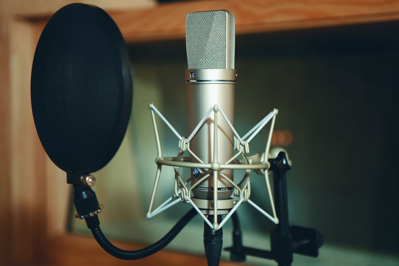 About Close-up of a studio microphone with pop filter, perfect for recording.